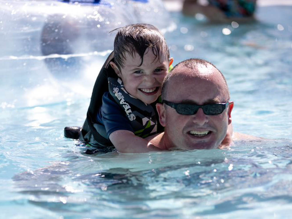 Father and son playing in the pool.